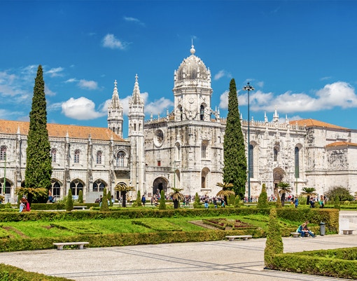 Jeronimos Monastery in Lisbon with ornate architecture and manicured gardens.