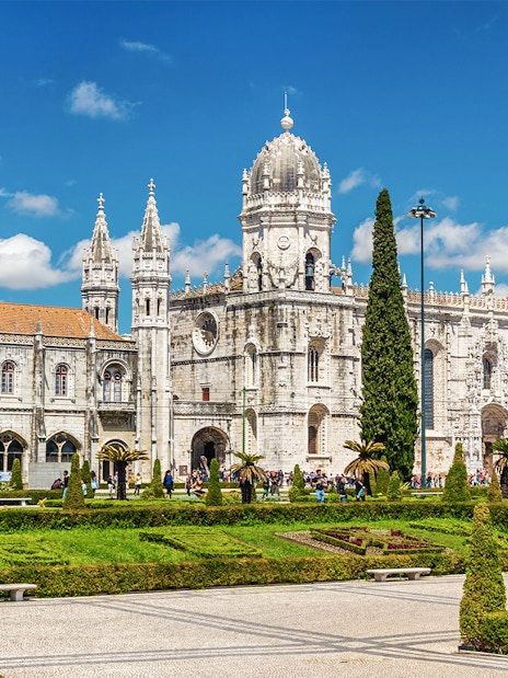 Jeronimos Monastery in Lisbon with ornate architecture and manicured gardens.