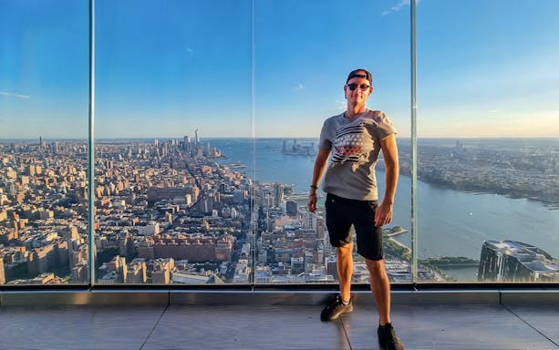 Man on observation deck overlooking New York City skyline.