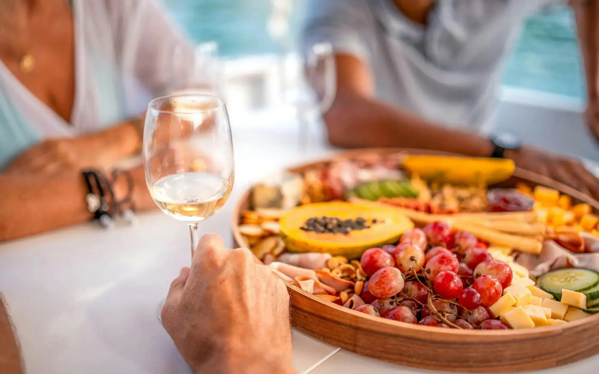 Wine glass and fruit platter on Albufeira sunset sailing tour.