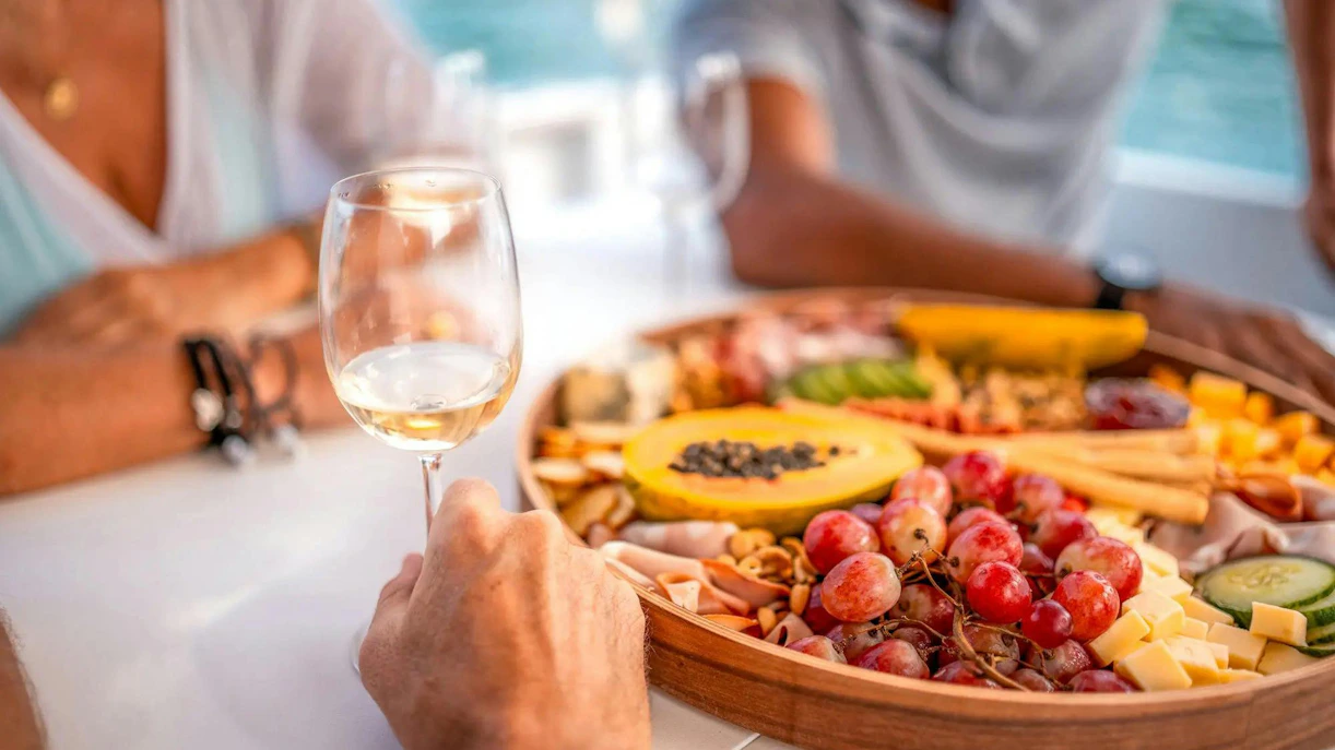 Wine glass and fruit platter on Albufeira sunset sailing tour.