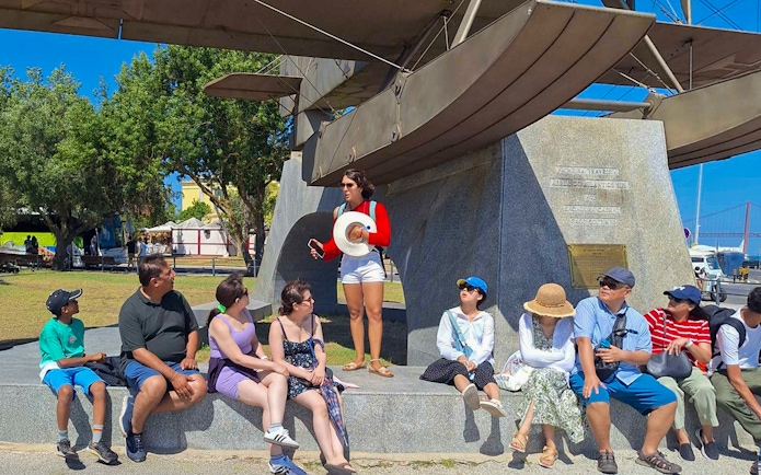 Tourist group with guide near Jeronimos Monastery monument in Lisbon.