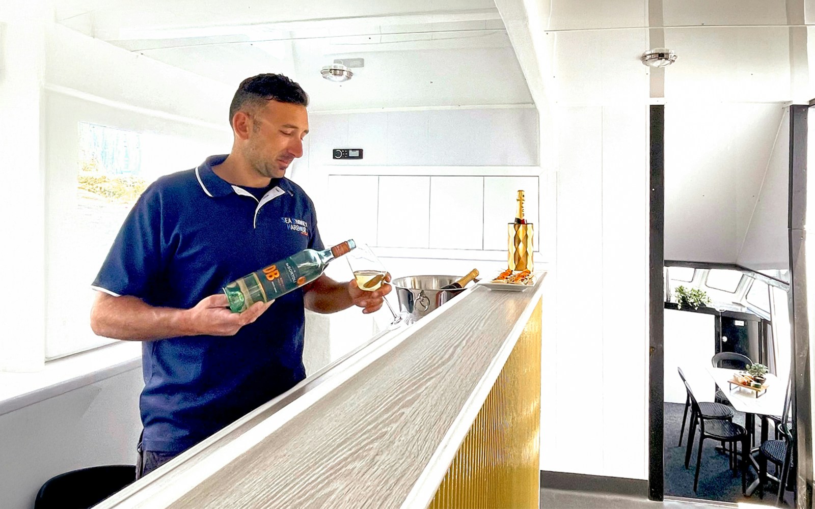 Staff pouring out wine during the Golden Glow Sunset Harbour Cruise