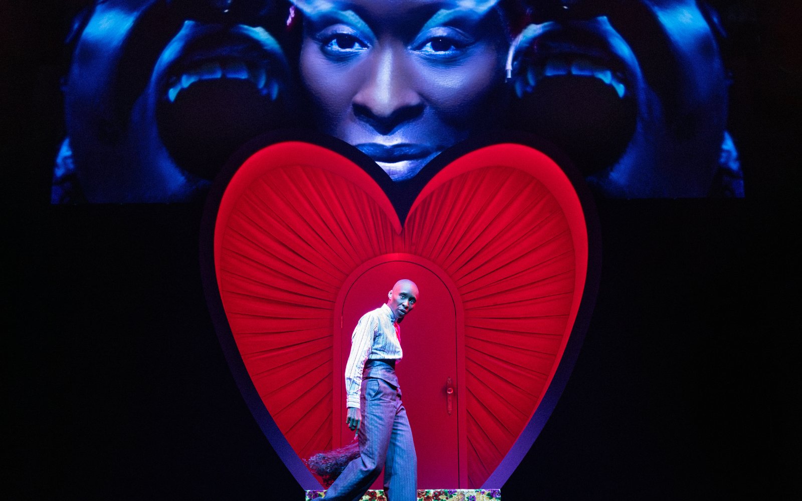 Performer on stage with red heart backdrop in Dracula Westend show.