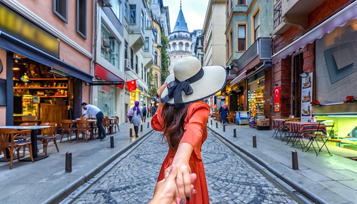 Couple posing on Istanbul street with Galata Tower in the background.