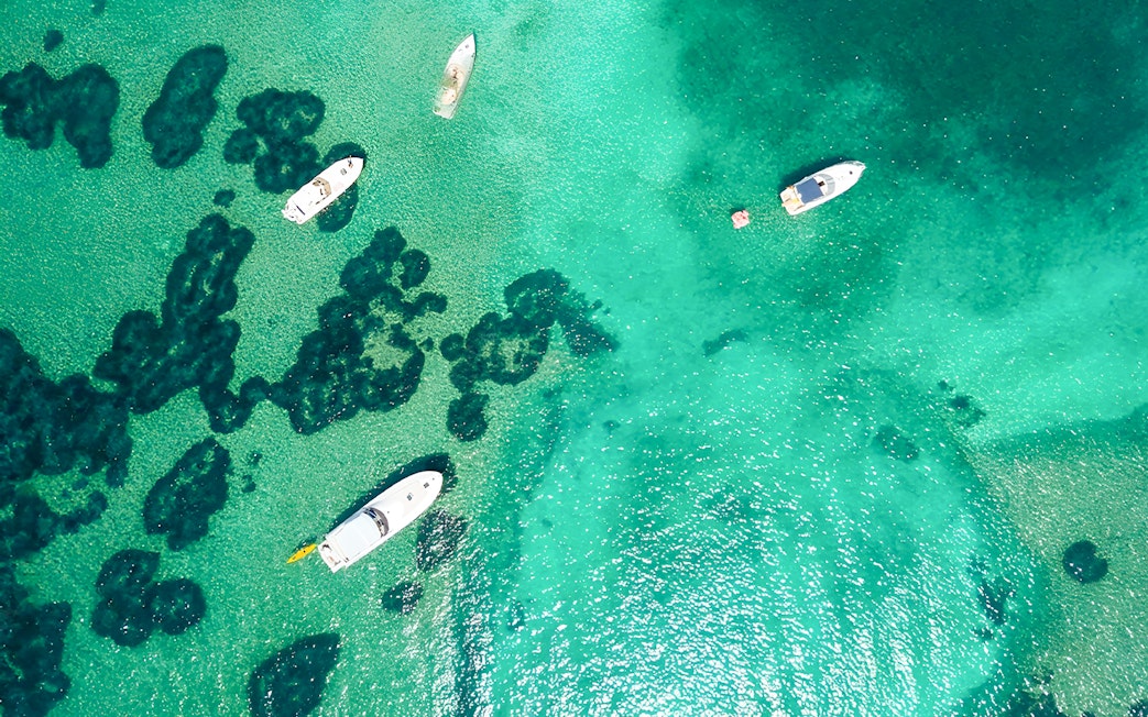 Boats on turquoise waters near Elaphiti Islands, Dubrovnik, during a Blue Cave tour.