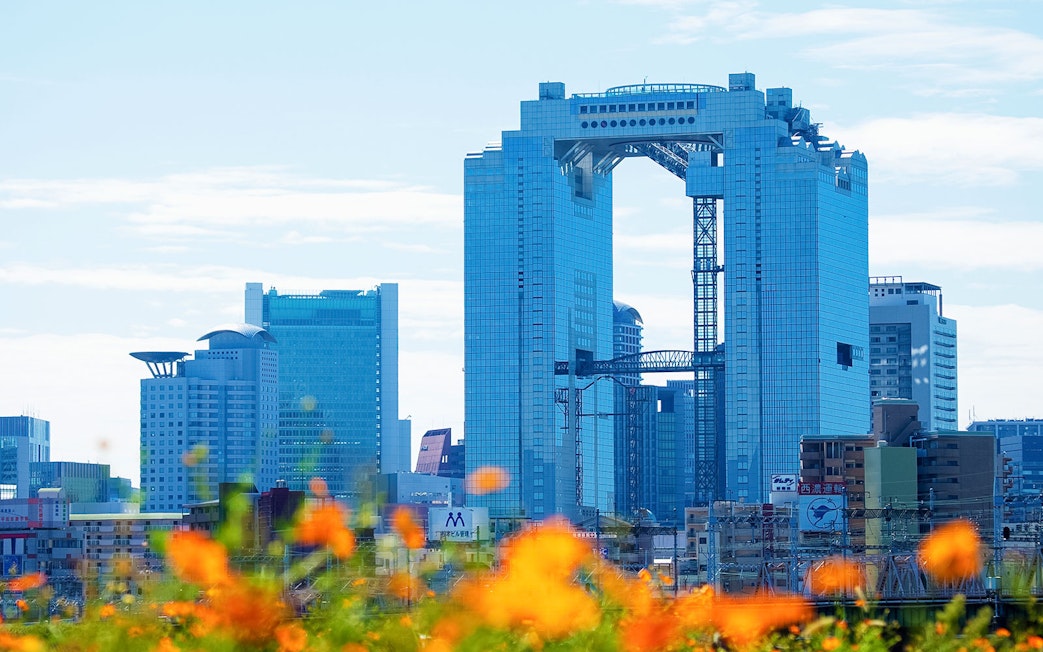 Umeda Sky Building in Osaka with orange flowers in the foreground.