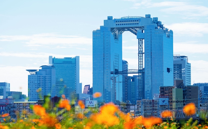 Umeda Sky Building in Osaka with orange flowers in the foreground.