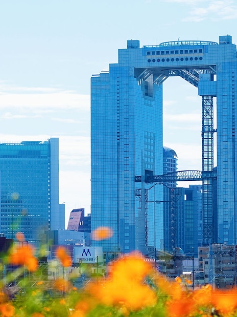 Umeda Sky Building in Osaka with orange flowers in the foreground.