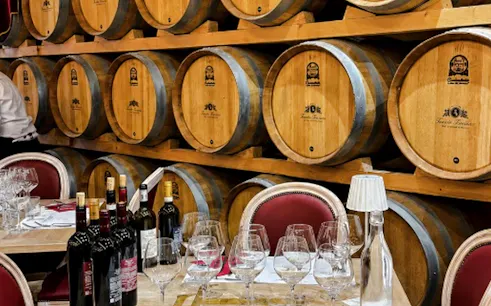 Wine barrels and tasting setup at a Tuscan winery near San Gimignano, Italy.