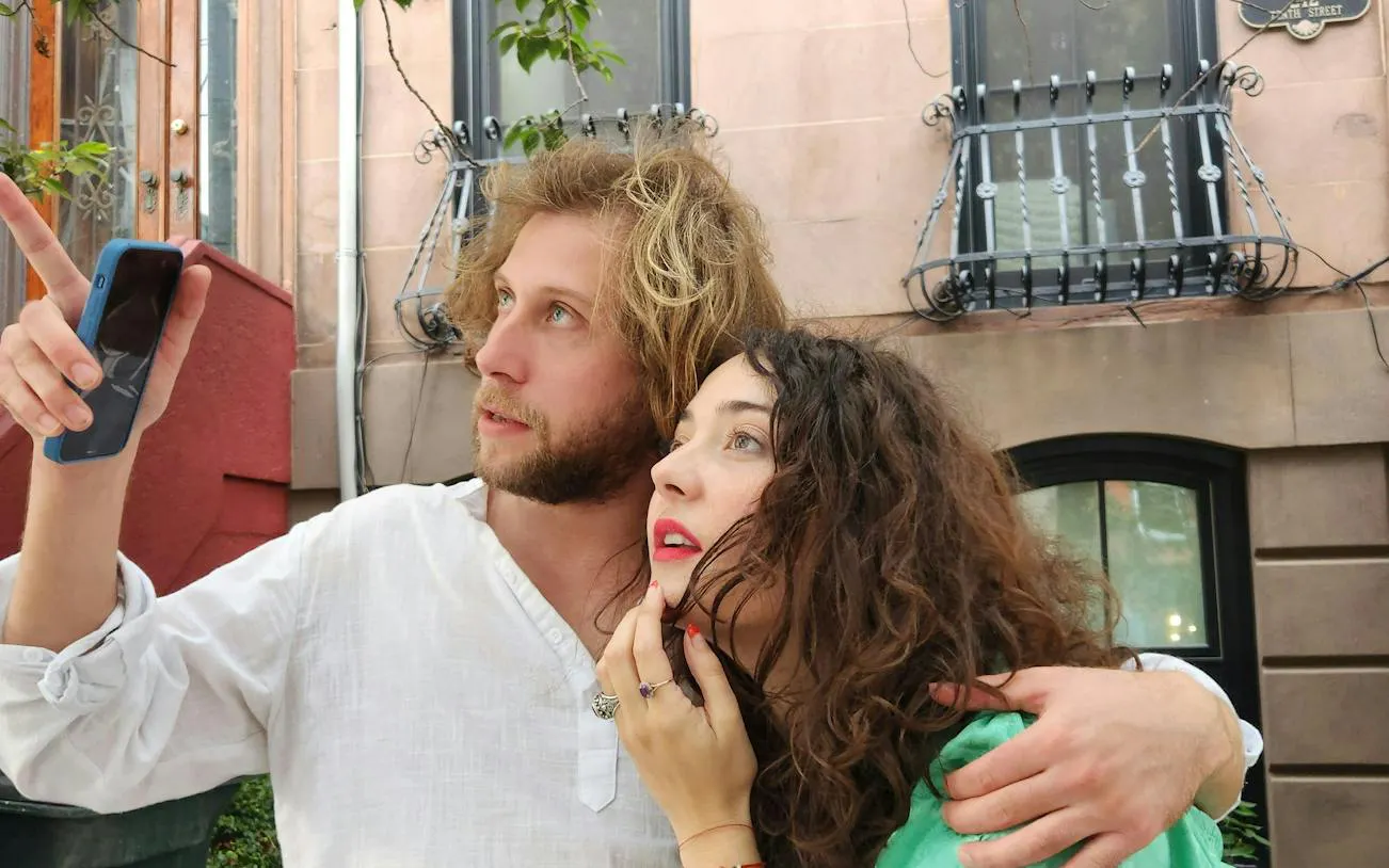 Couple exploring New York with a smartphone, participating in a self-guided city exploration game.