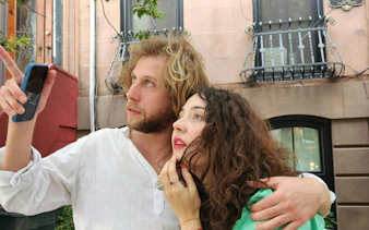 Couple exploring New York with a smartphone, participating in a self-guided city exploration game.