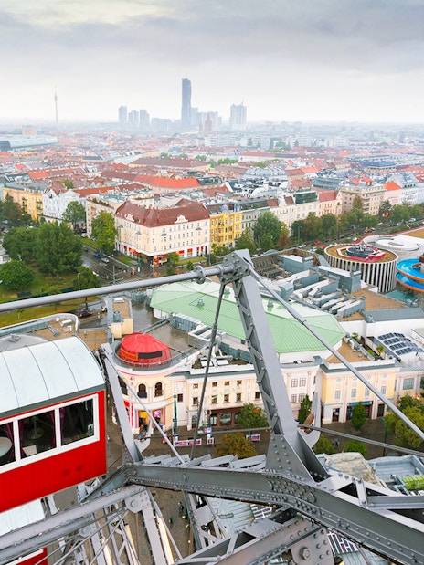 View of Vienna from the Giant Ferris Wheel, showing cityscape and amusement park below.