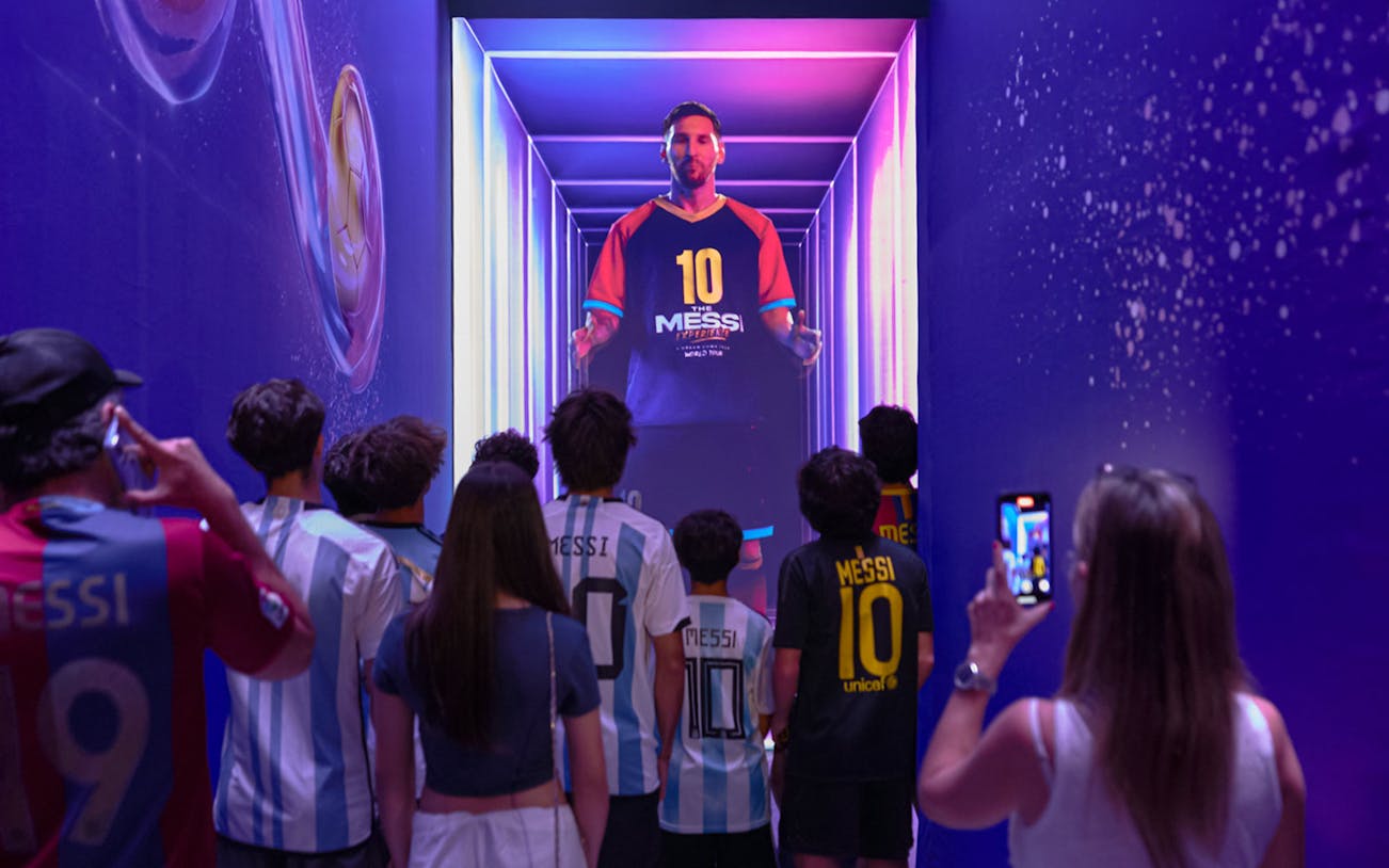 Visitors viewing a digital display at The Messi Experience in Dubai.