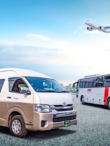 Kansai Airport shuttle van and bus with city skyline and airplane in background.