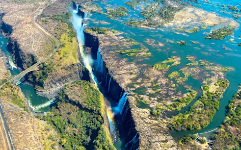 Aerial view of Victoria Falls with surrounding landscape and Zambezi River.
