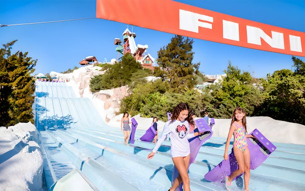 Kids exiting water slide with boards at Walt Disney World Resort, Orlando.