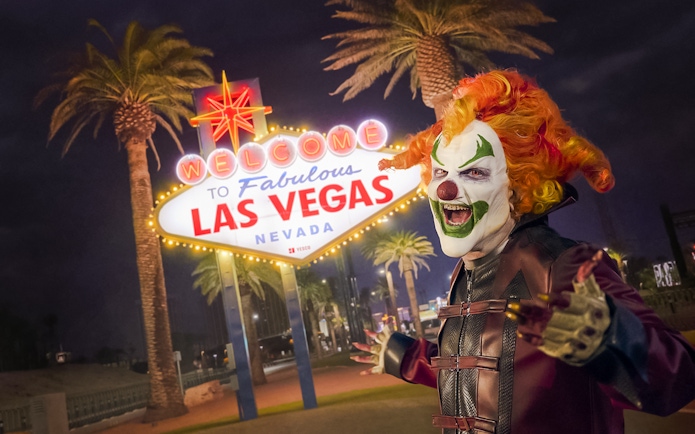 Clown in front of the Welcome to Las Vegas sign at night for Universal Horror Unleashed event.
