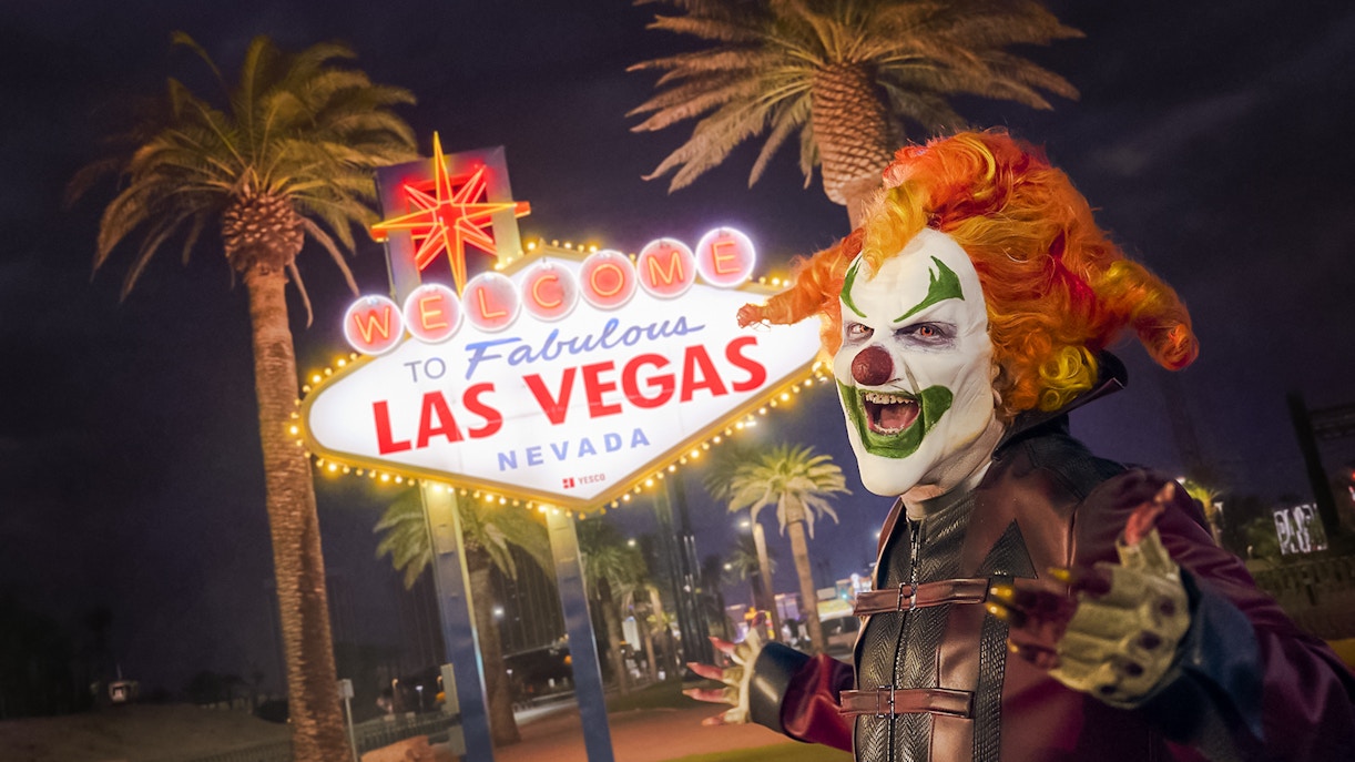 Clown in front of the Welcome to Las Vegas sign at night for Universal Horror Unleashed event.