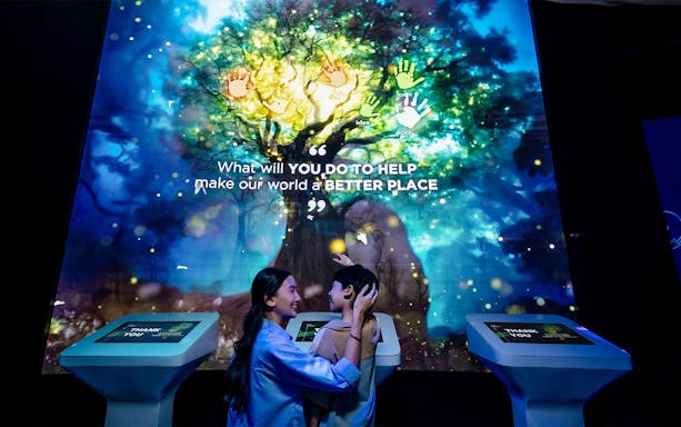 Interactive display at Better World Better Future exhibit with participants engaging.