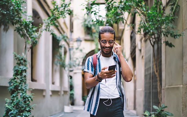 Person using audio guide app in Montmartre, Paris.