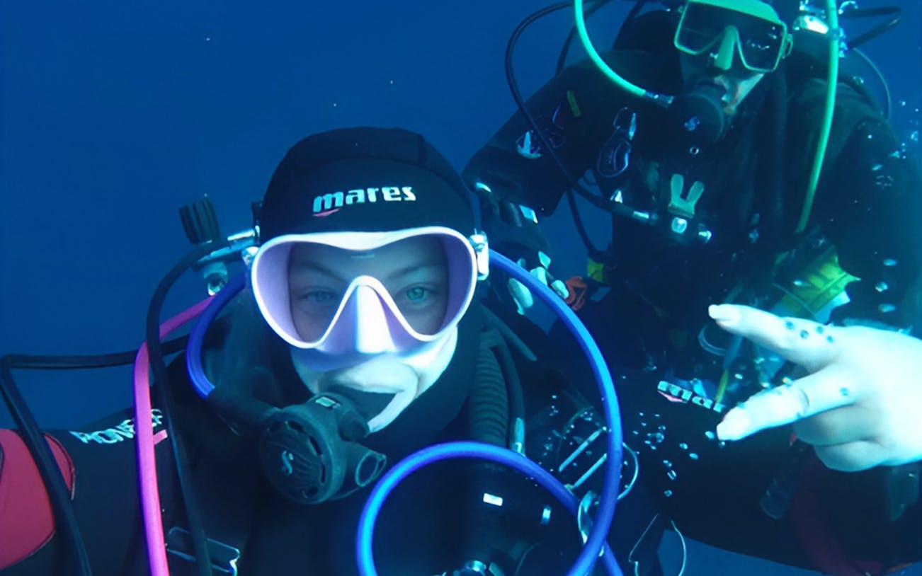 Certified divers exploring underwater in Aci Castello.