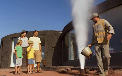Family observing geothermical water demonstration at Timanfaya National Park, Lanzarote.