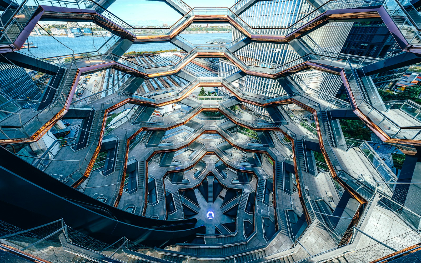 Vessel's intricate staircases and platforms in New York City with river view.