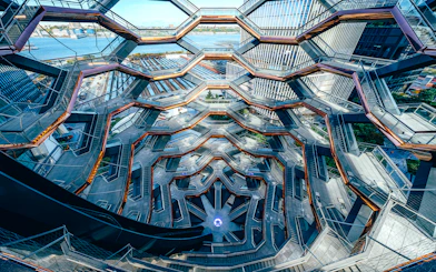 Vessel's intricate staircases and platforms in New York City with river view.