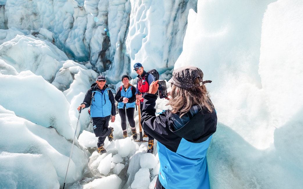 Hikers taking photos on Fox Glacier, New Zealand.