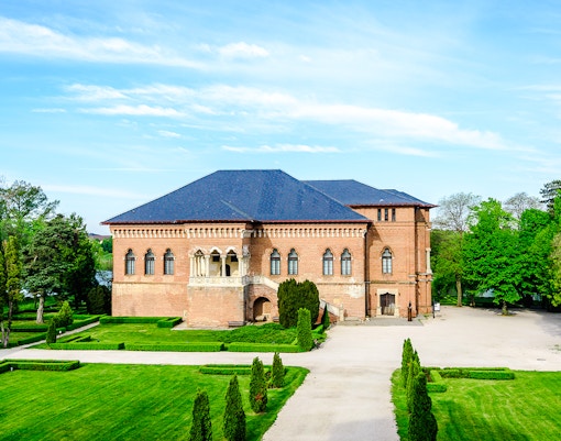 Mogosoaia Palace in Romania surrounded by lush gardens and trees.