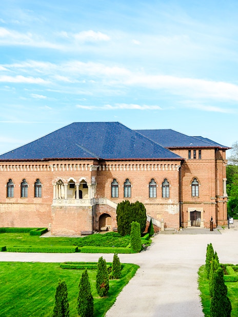 Mogosoaia Palace in Romania surrounded by lush gardens and trees.