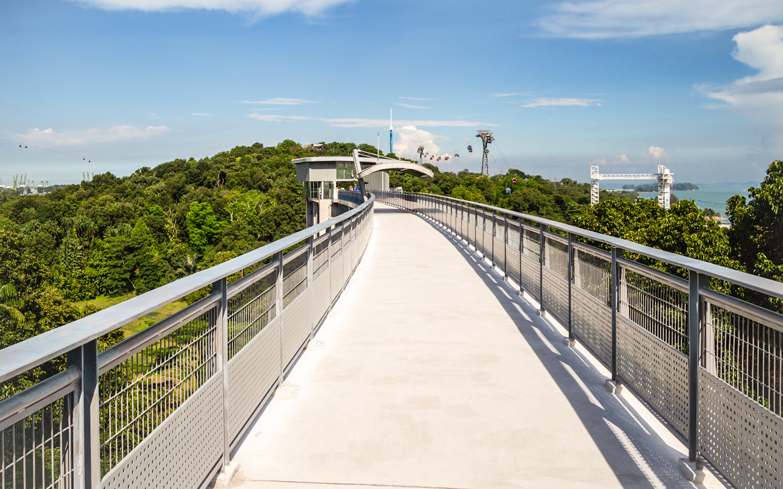 Elevated walkway on Sentosa Island, Singapore, with cable cars in the background.