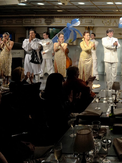 Performers on stage at Gala Tango Show in Buenos Aires, Argentina, with audience clapping.