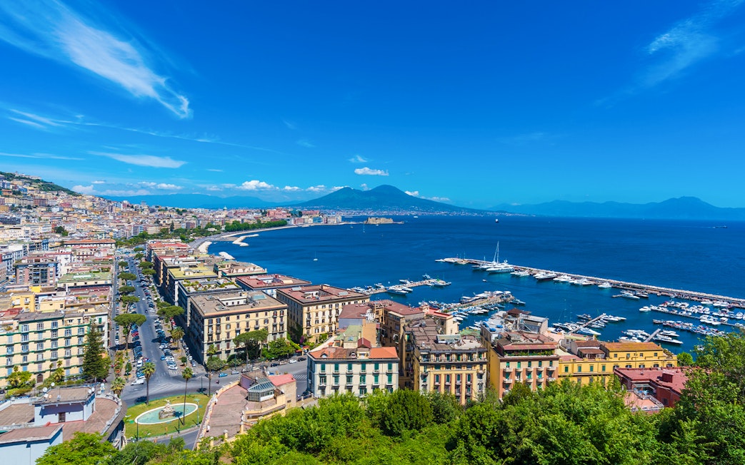 Panoramic view of Naples cityscape with Mount Vesuvius in the background.