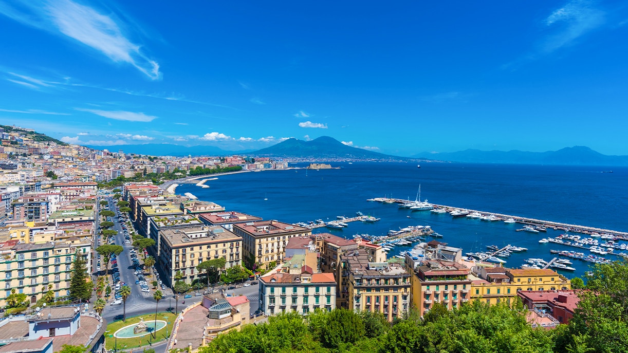 Panoramic view of Naples cityscape with Mount Vesuvius in the background.