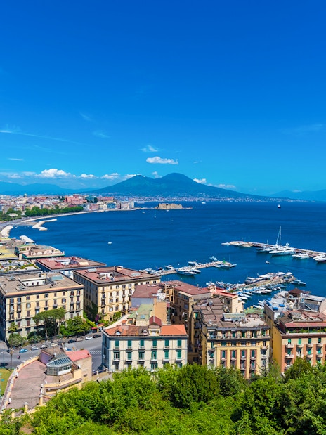 Panoramic view of Naples cityscape with Mount Vesuvius in the background.