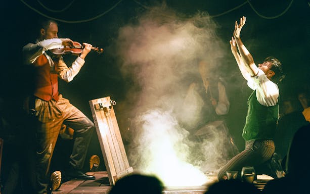 Violinist and performer in dramatic scene at The Great Christmas Feast.