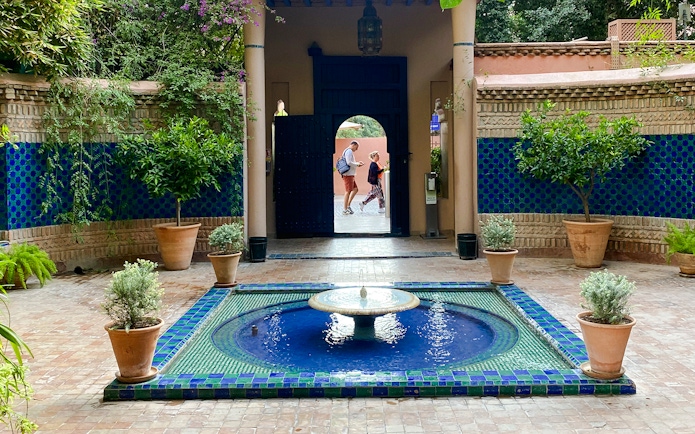 Jardin Majorelle courtyard with blue-tiled fountain and lush greenery.