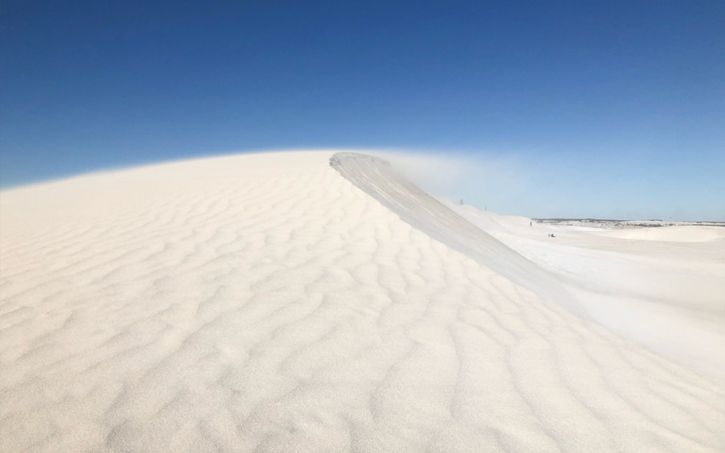 Sand dunes at Australia's Pinnacles under clear blue sky.