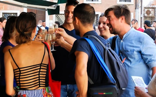 Group enjoying a toast during a guided food tour in Venice.
