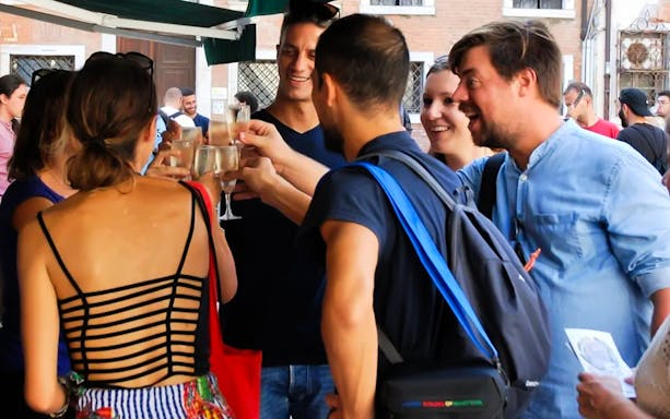 Group enjoying a toast during a guided food tour in Venice.