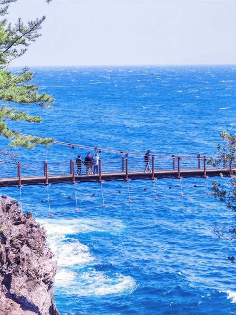 Kadowaki Suspension Bridge over blue ocean on Jogasaki Coast, Ito, Shizuoka, Japan.