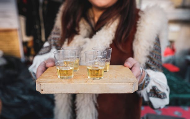 Drinks served on a wooden tray during Hungarian ranch tour from Budapest.