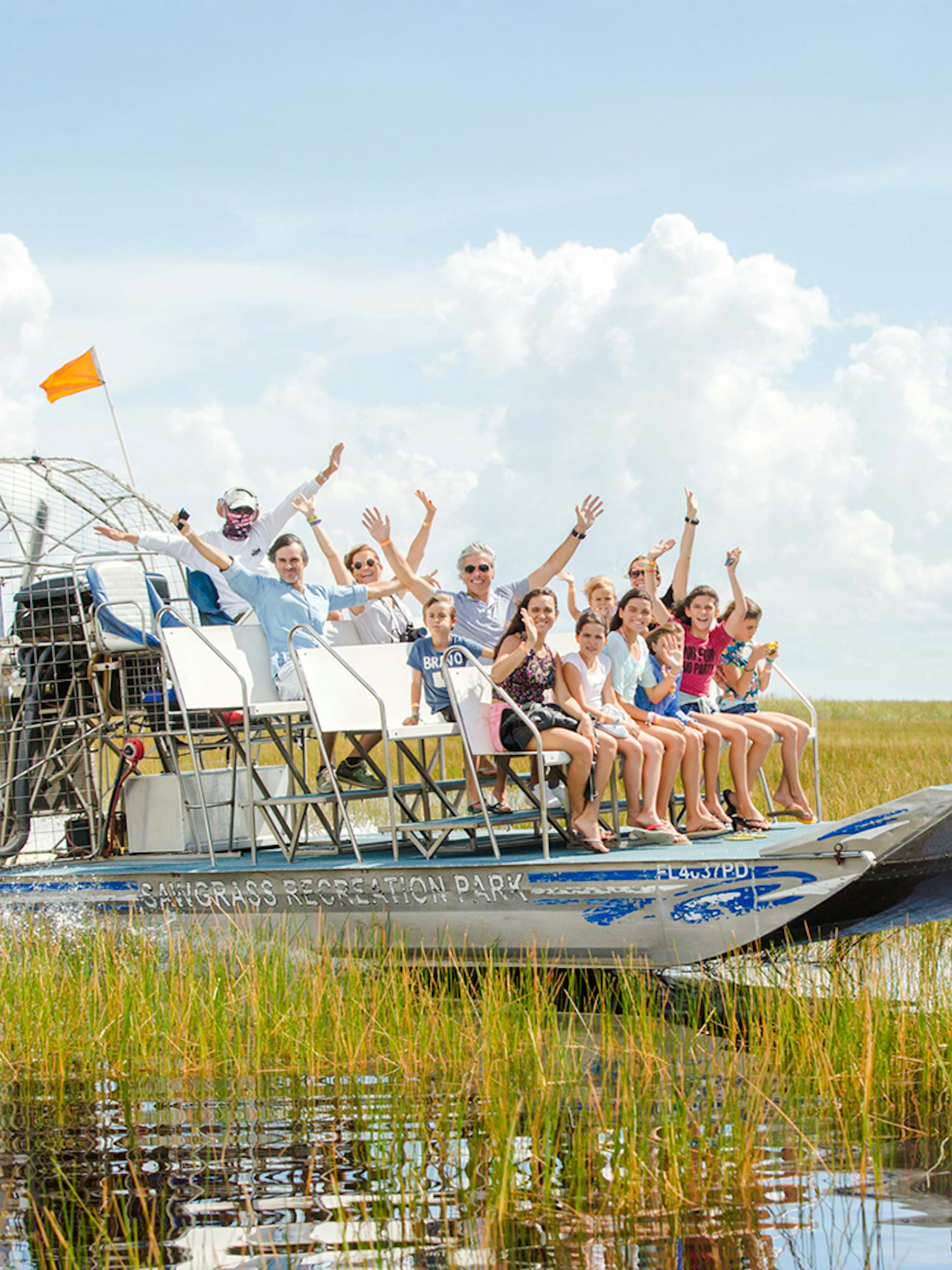Group enjoying an Everglades private airboat tour through marshlands.