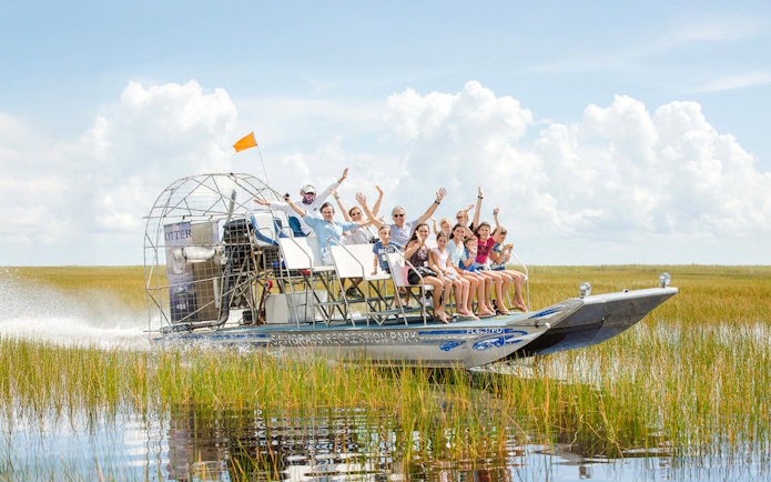 Group enjoying an Everglades private airboat tour through marshlands.