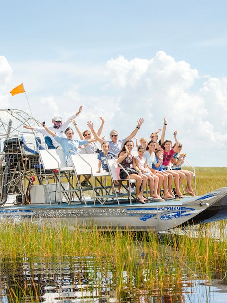 Group enjoying an Everglades private airboat tour through marshlands.
