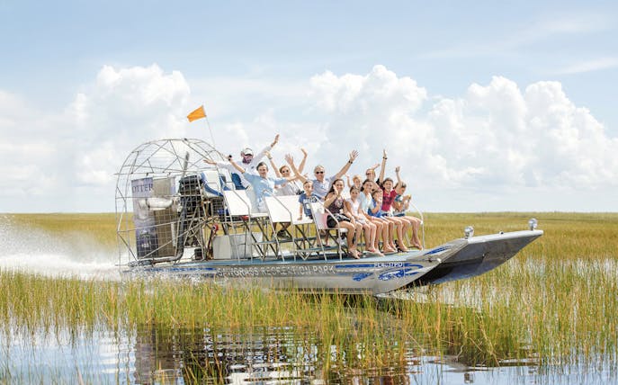 Group enjoying an Everglades private airboat tour through marshlands.
