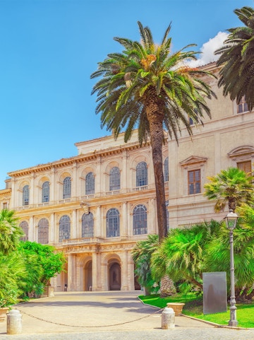 Barberini Palace facade with palm trees, Rome, Italy.