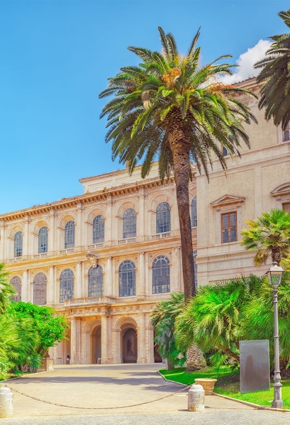 Barberini Palace facade with palm trees, Rome, Italy.